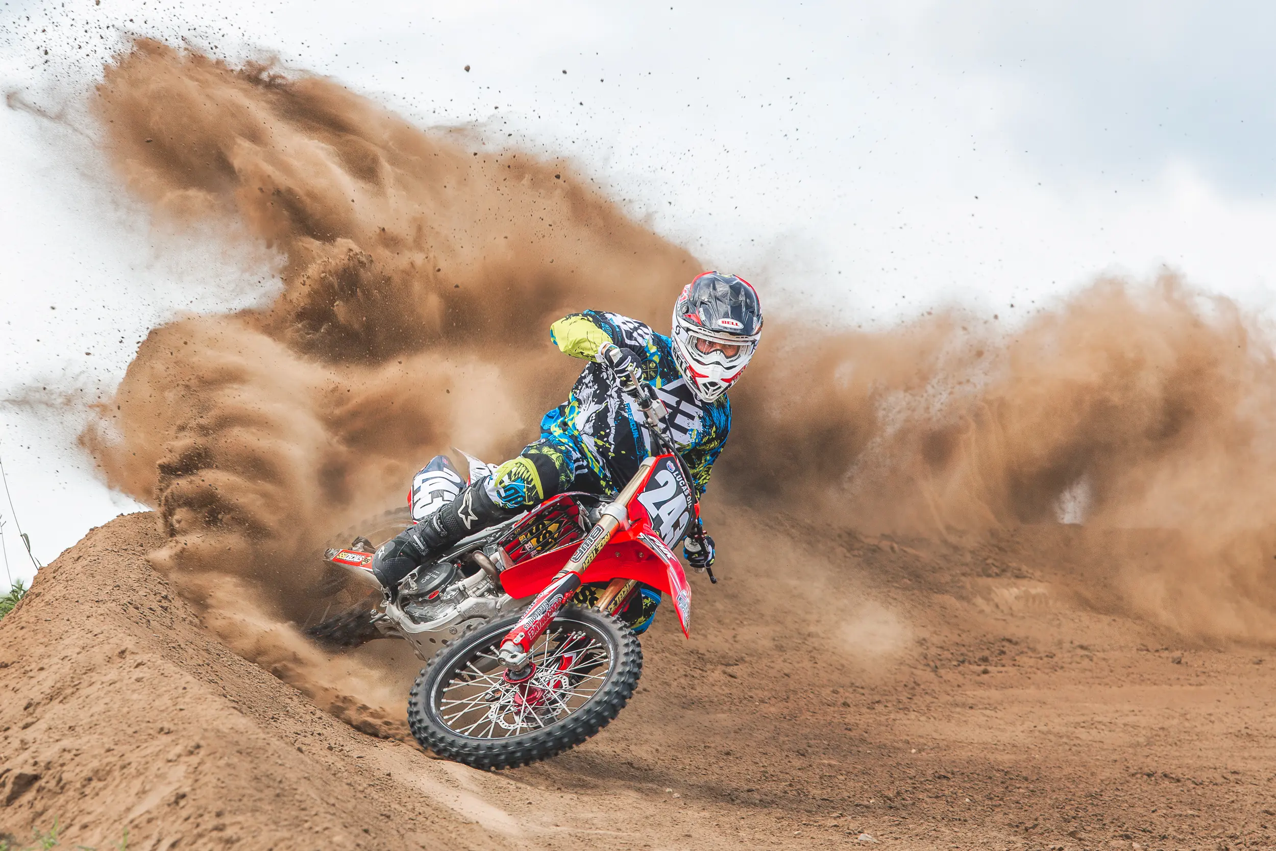Motocross racer driving through a cloud of roost