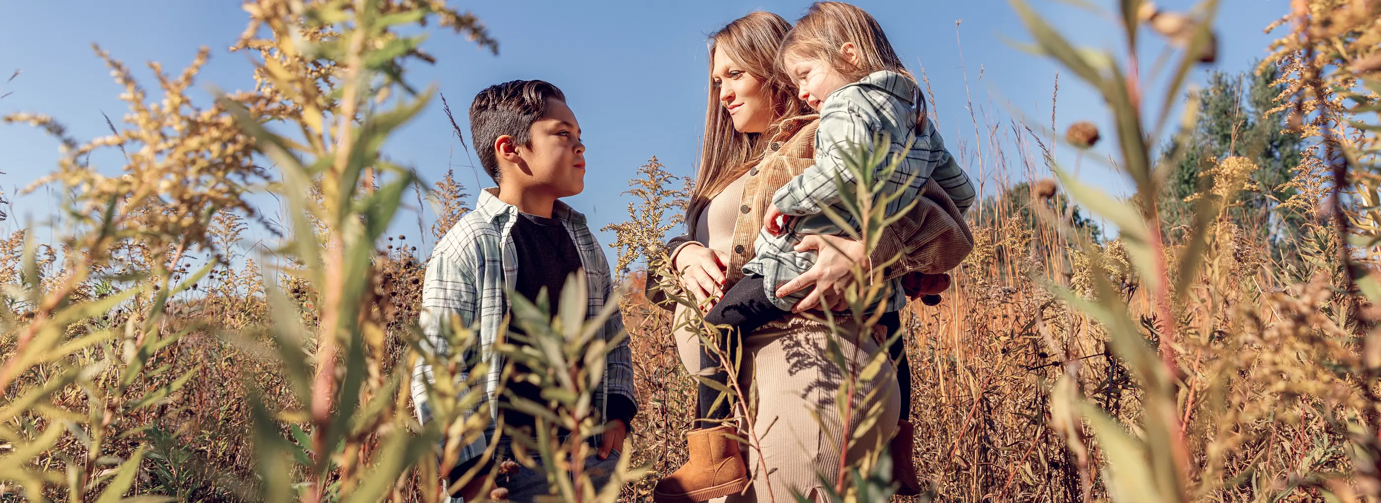 Mother and children sharing a warm moment in an autumn field