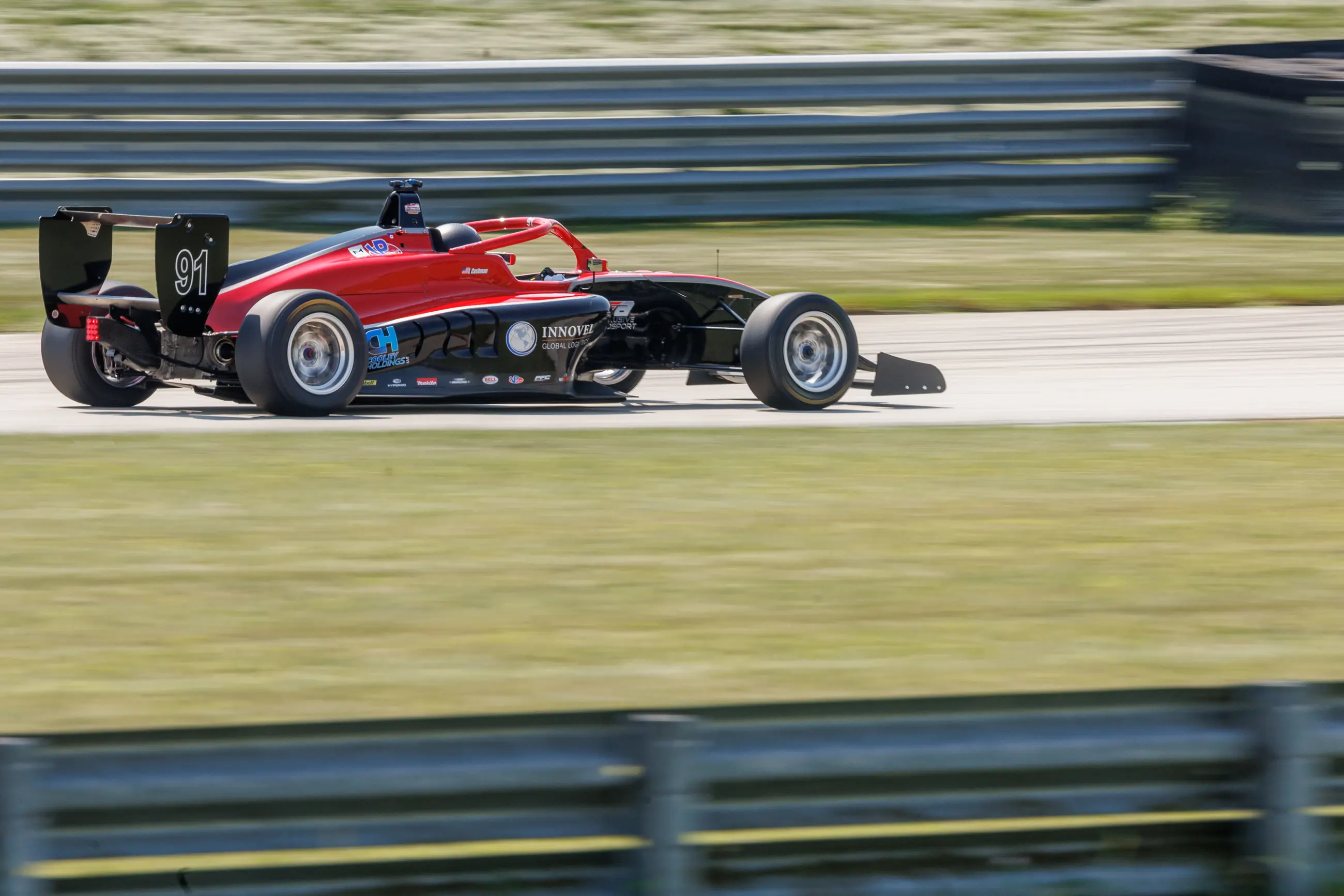 Formula 4 race car photographed at speed at Autobahn Country Club